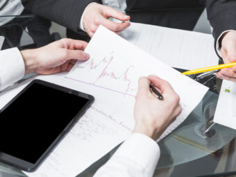close-up-two-businesspeople-analyzing-report-office